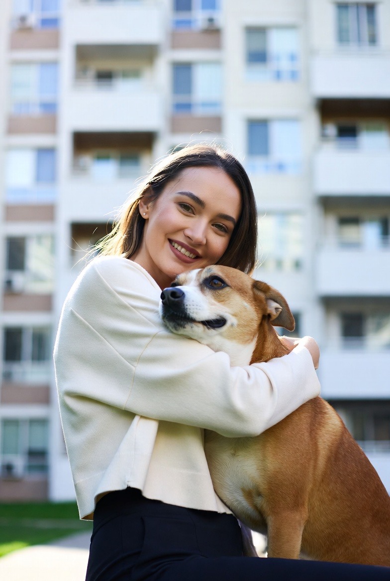 Resident with dog in front of apartments